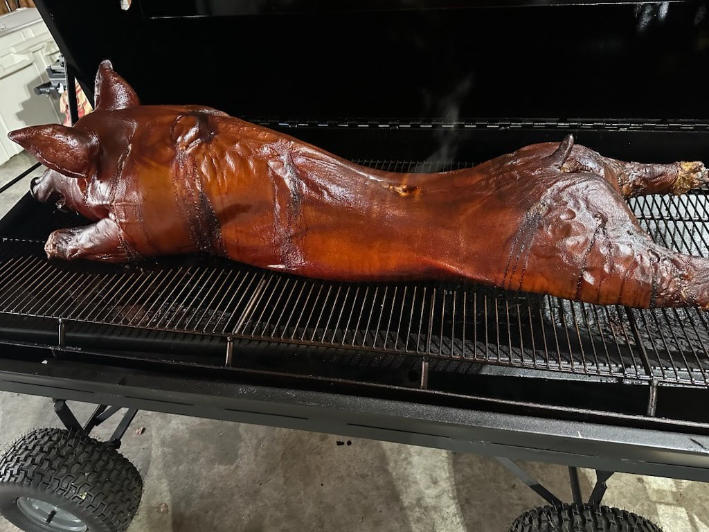 Whole pig roasting on the smoker